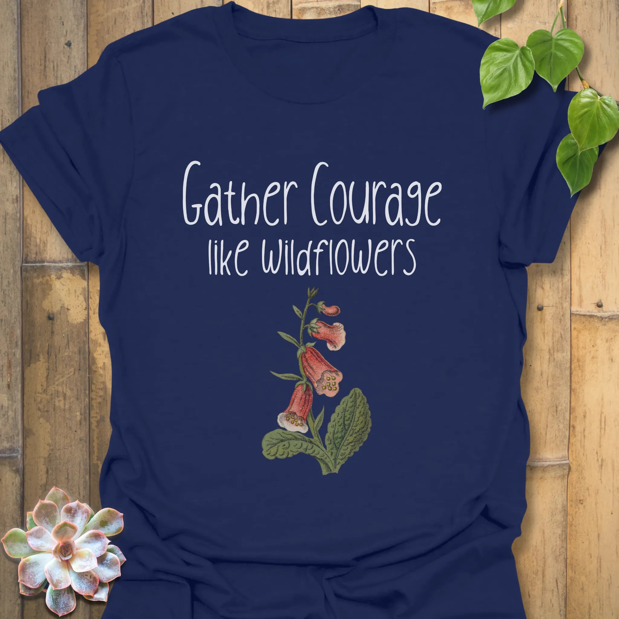 Navy botanical graphic t-shirt with the motivational words ‘Gather courage like wildflowers’ and an elegant flower illustration