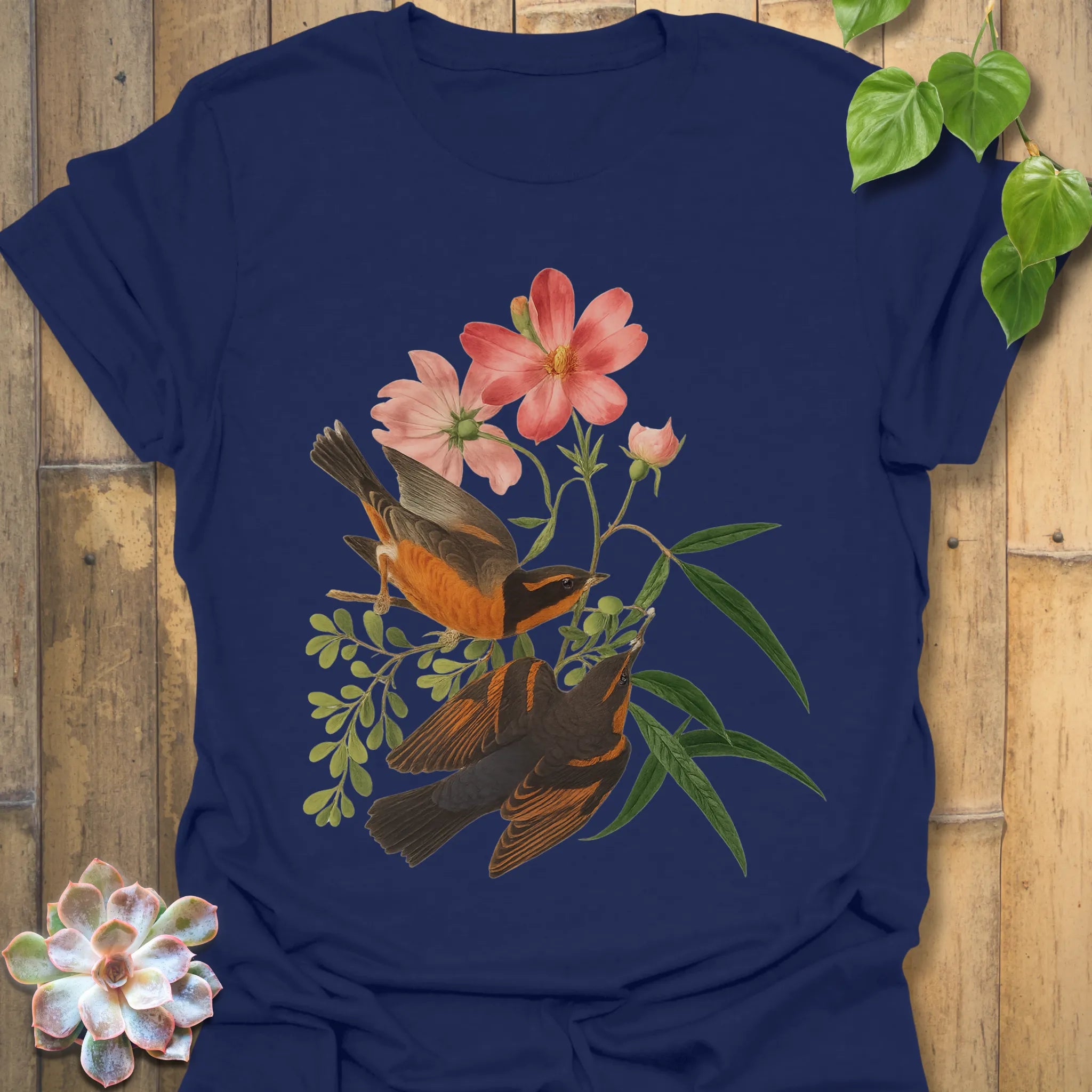 Navy t-shirt featuring the Spring Songbirds artwork with two birds among blooming pink flowers and green foliage