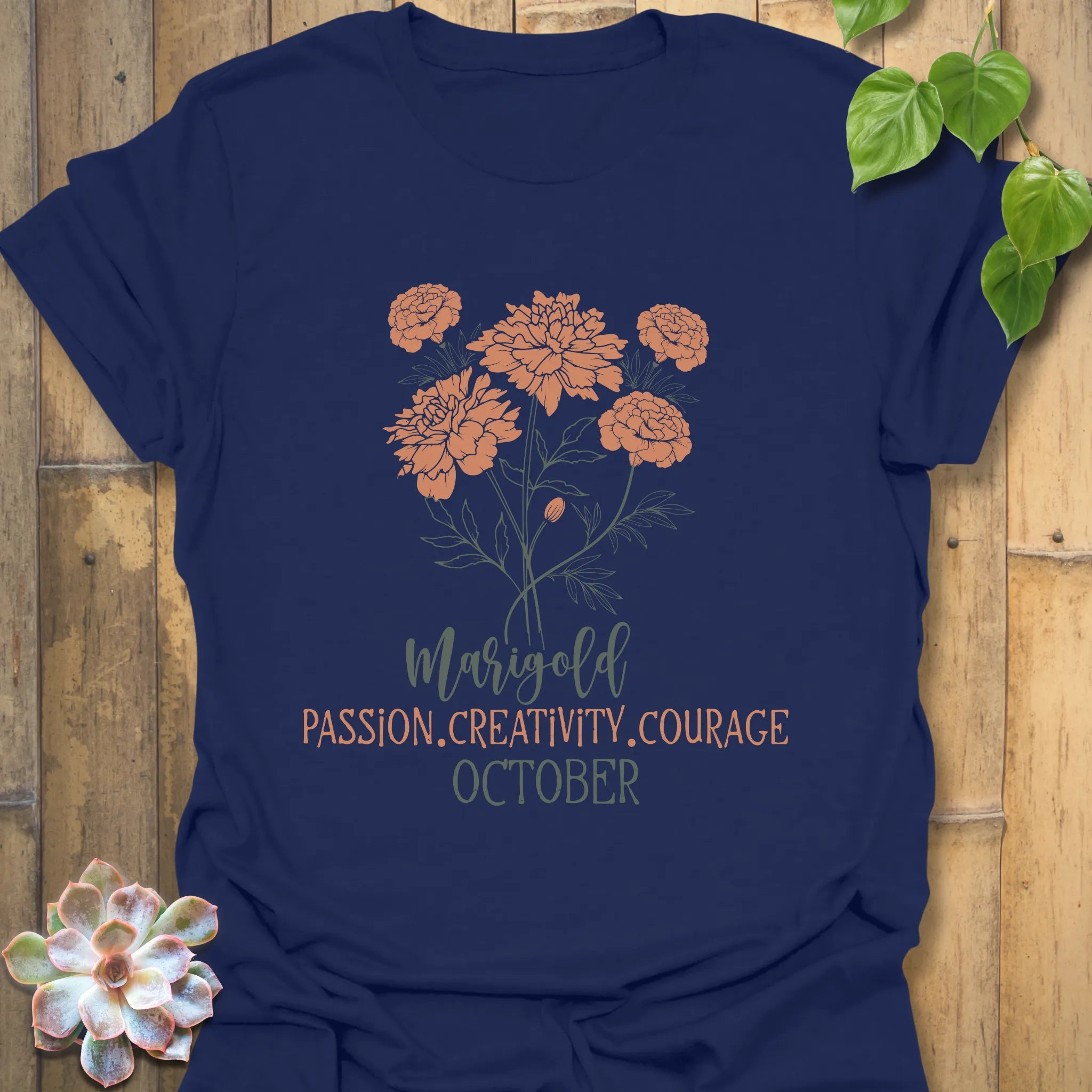 Navy t-shirt featuring the design October Marigold printed with a vibrant marigold flower, a chic floral botanical graphic tee.