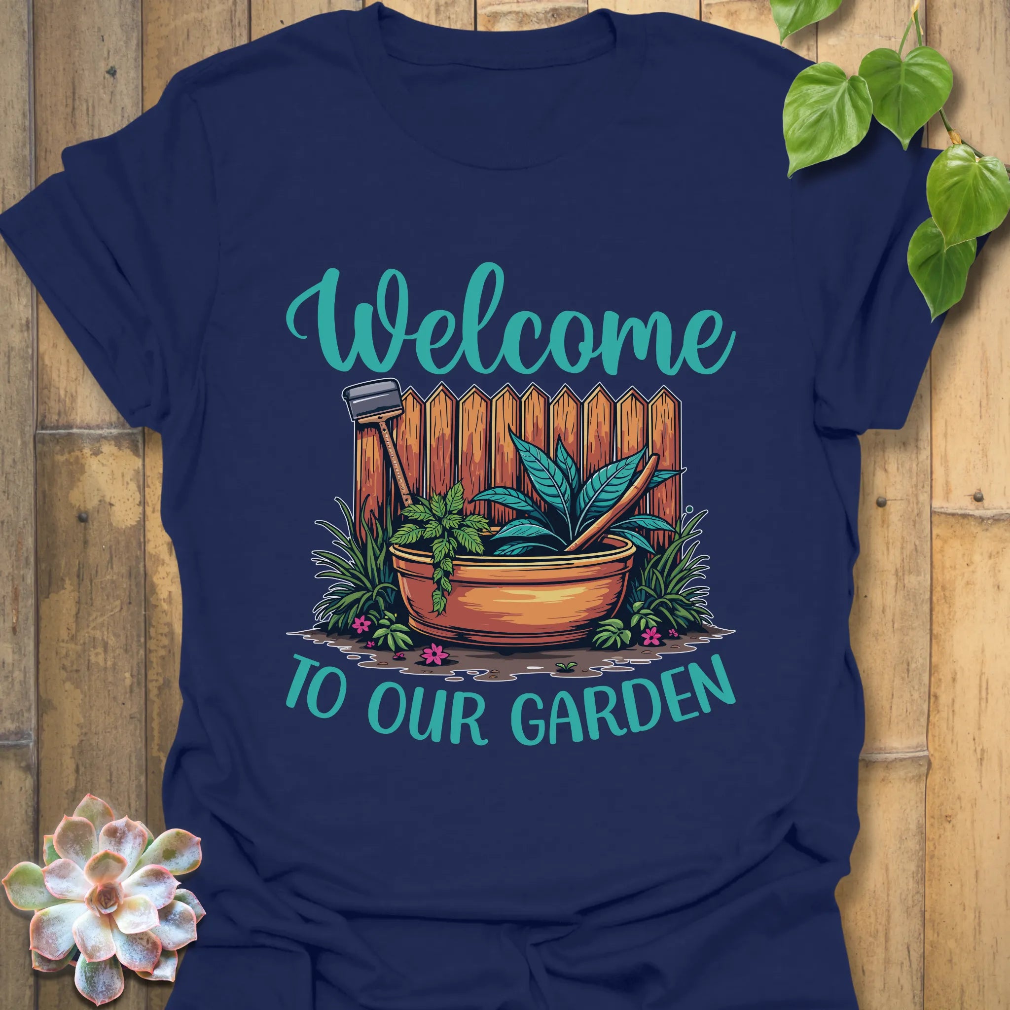 Navy t-shirt featuring the design Welcome to our garden with a garden scene, potted plant, and tools, a gardening graphic tee for outdoor and plant enthusiasts.