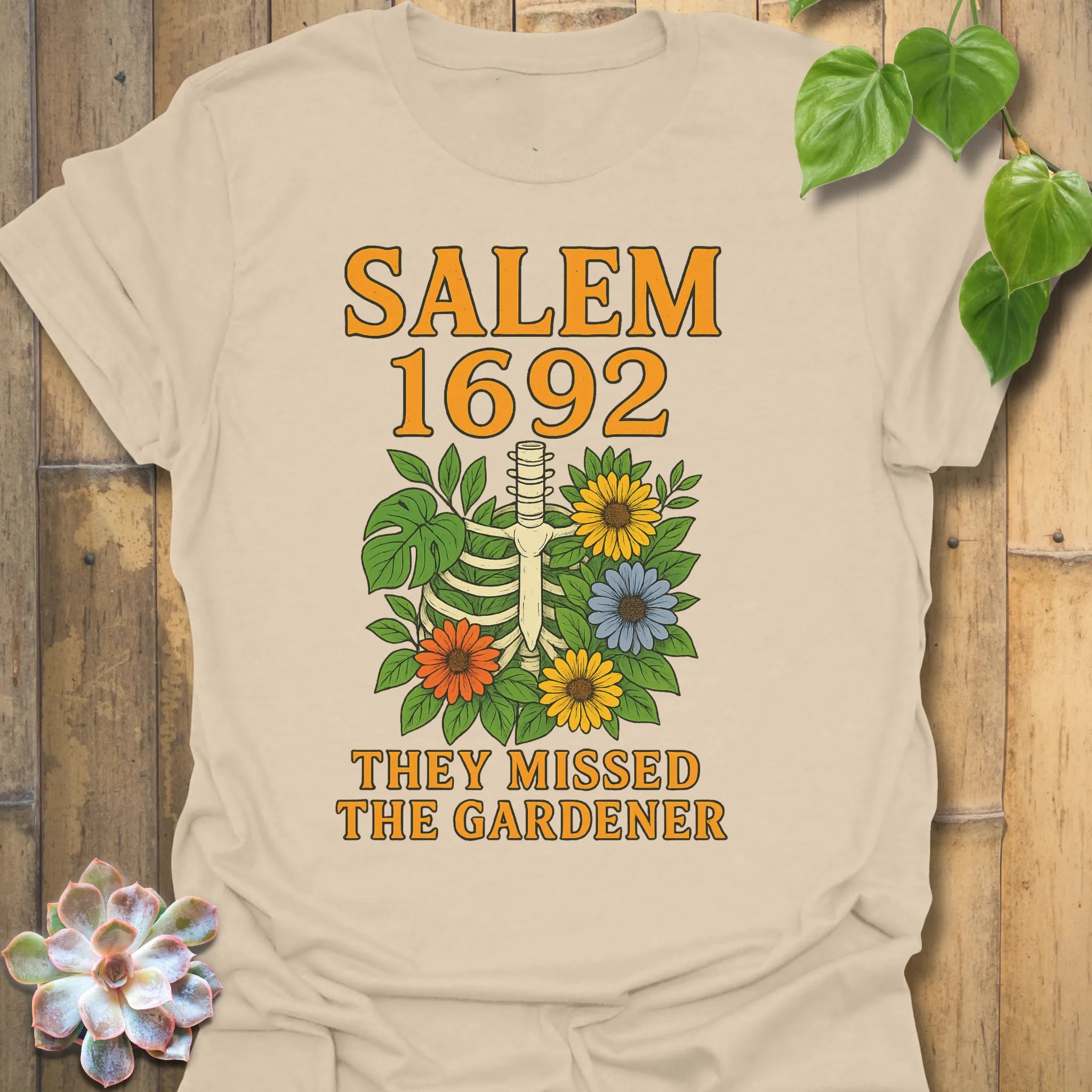 Sand t-shirt featuring the design Salem 1692 printed in bold letters, vintage halloween graphic tee.