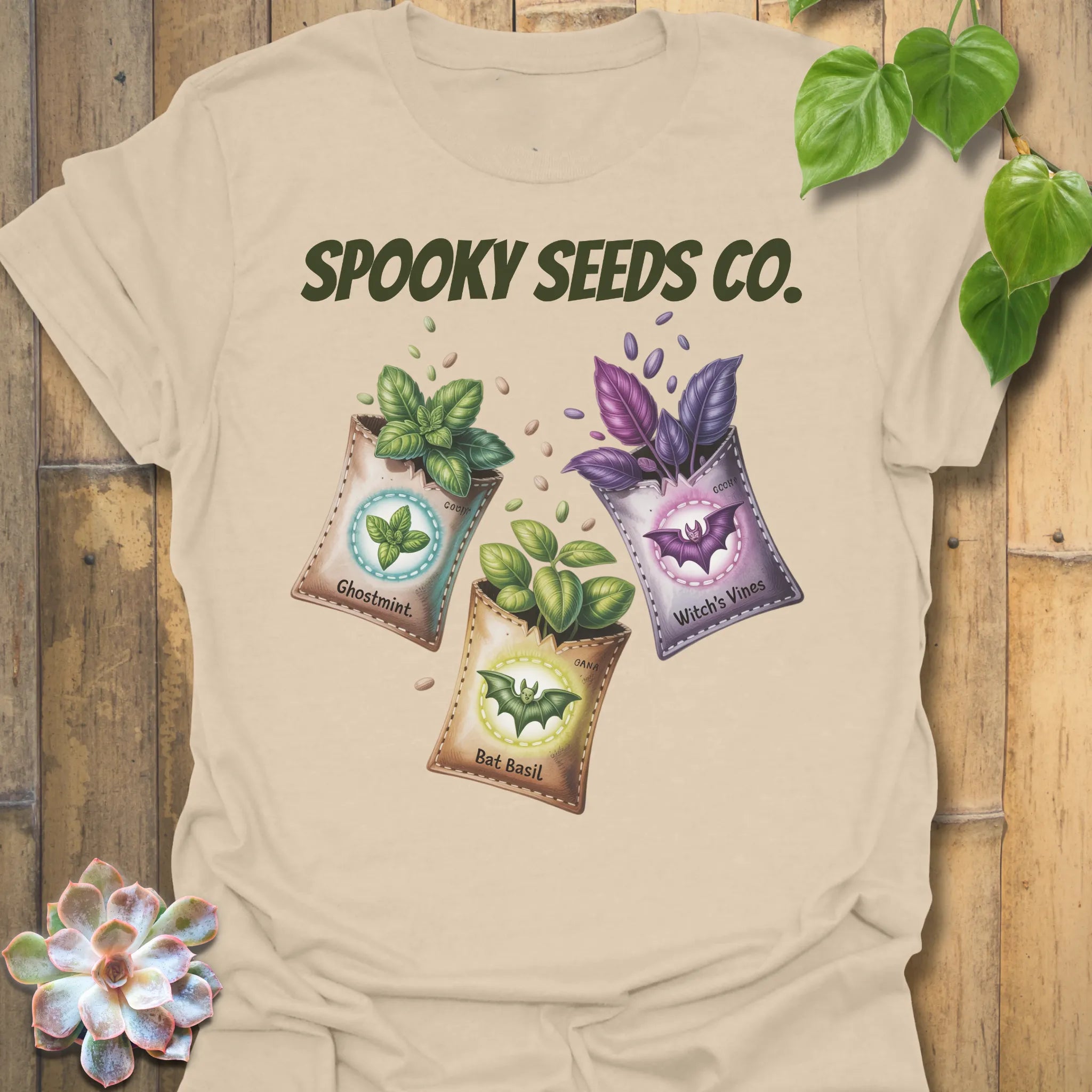 Sand t-shirt featuring the design Spooky Seeds Co. printed in bold letters, spooky plant lover shirt.