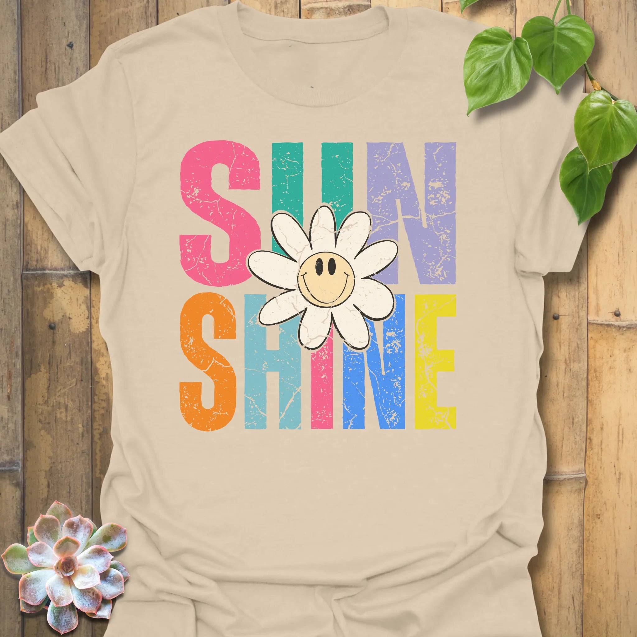 Sand t-shirt featuring the design Sunshine printed in bold colorful letters, funny sunflower casual summer shirt.
