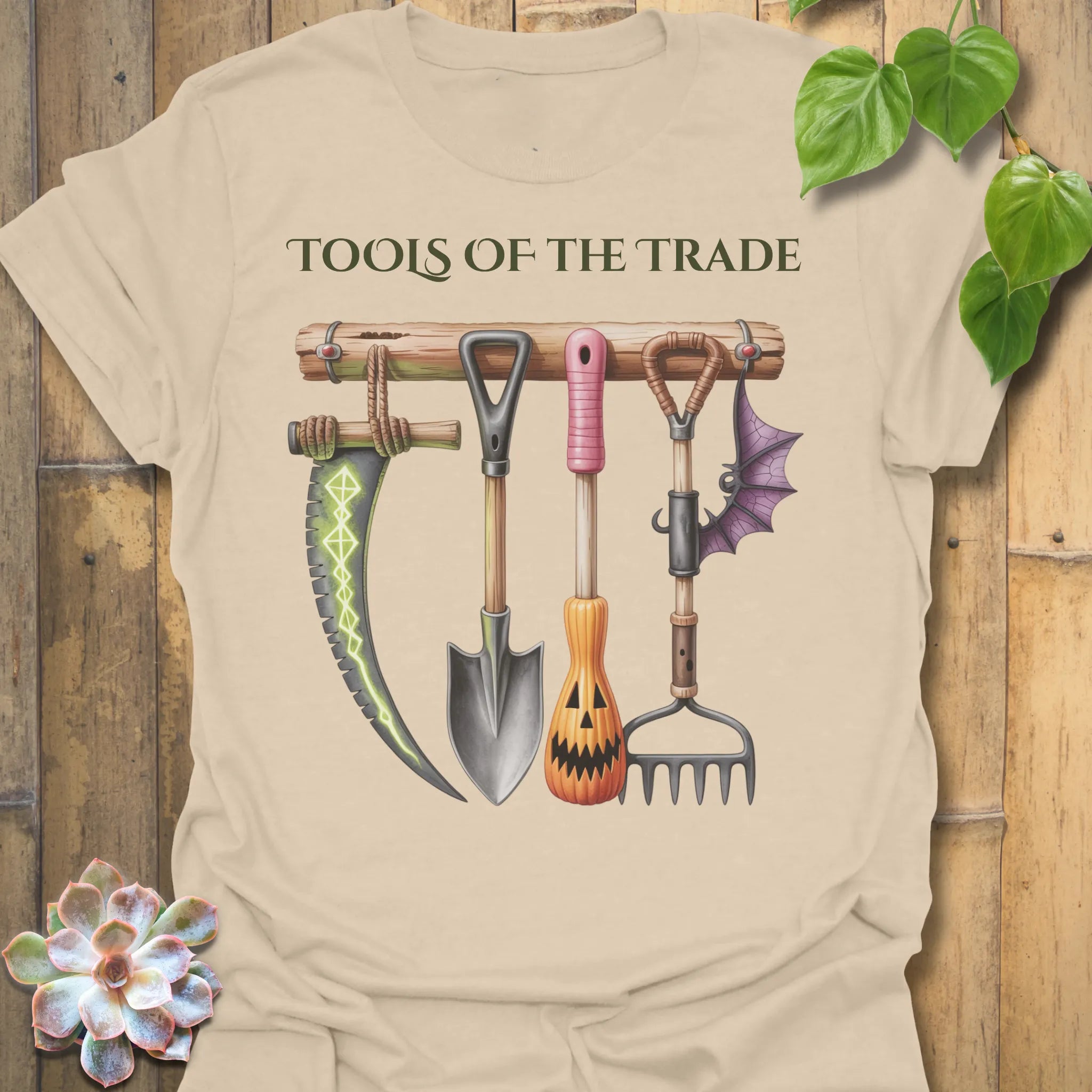 Sand t-shirt featuring the design Tools Of The Trade printed in bold letters, garden tools shirt.
