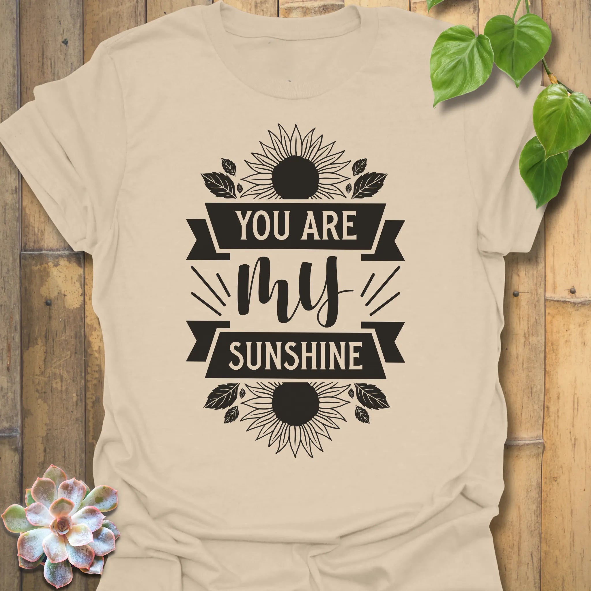 Sand t-shirt featuring the design You Are My Sunshine printed in bold letters, nature-inspired graphic tee.