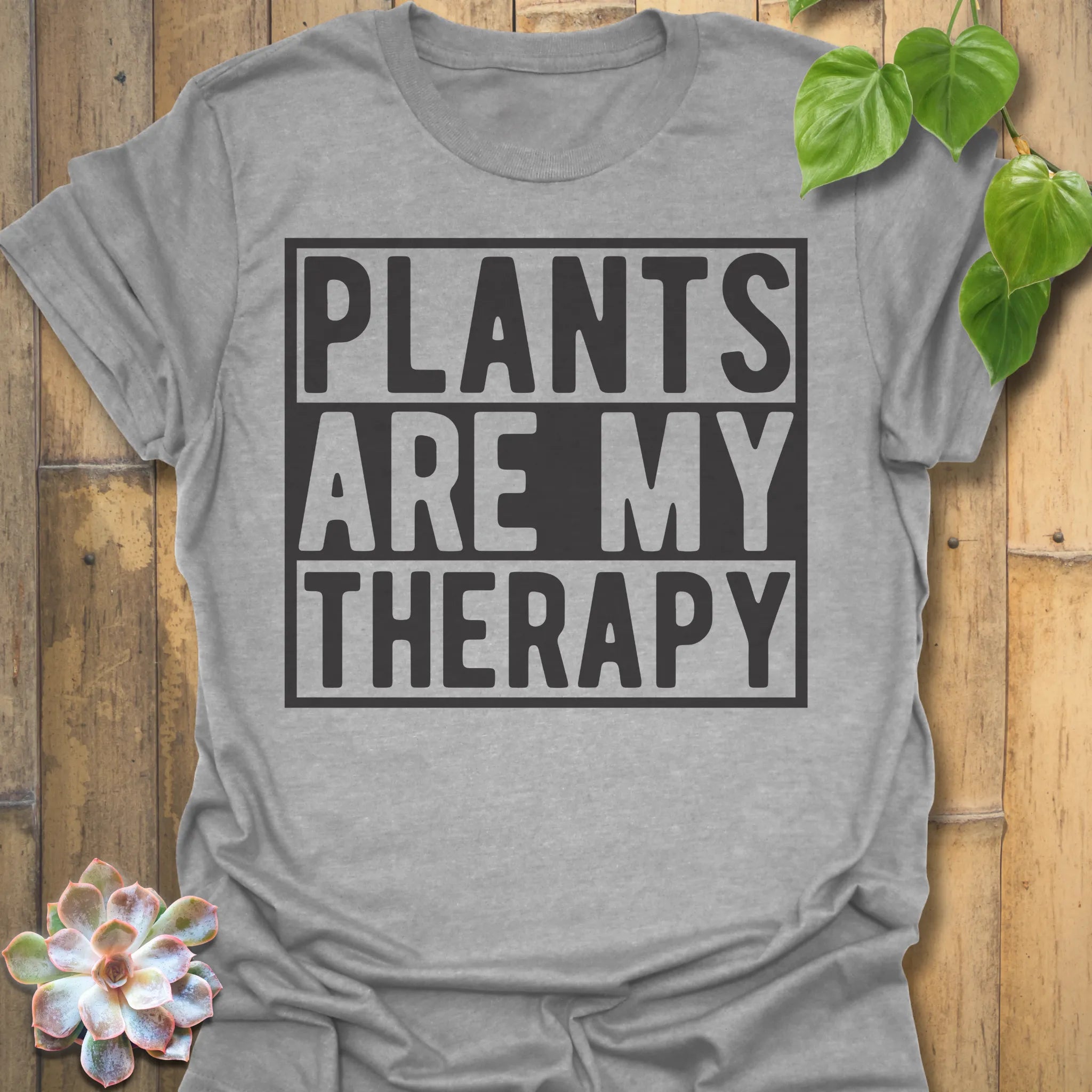 Sport Grey t-shirt featuring the design Plants Are My Therapy printed in bold letters, plant lover shirt.