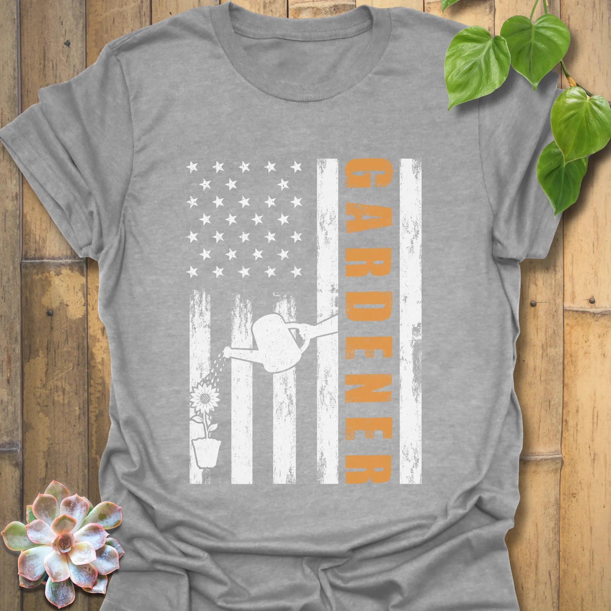Sport grey gardening graphic t-shirt featuring the design Gardener with a vertical word, American flag, plant, and watering sprinkler print, great for outdoor work