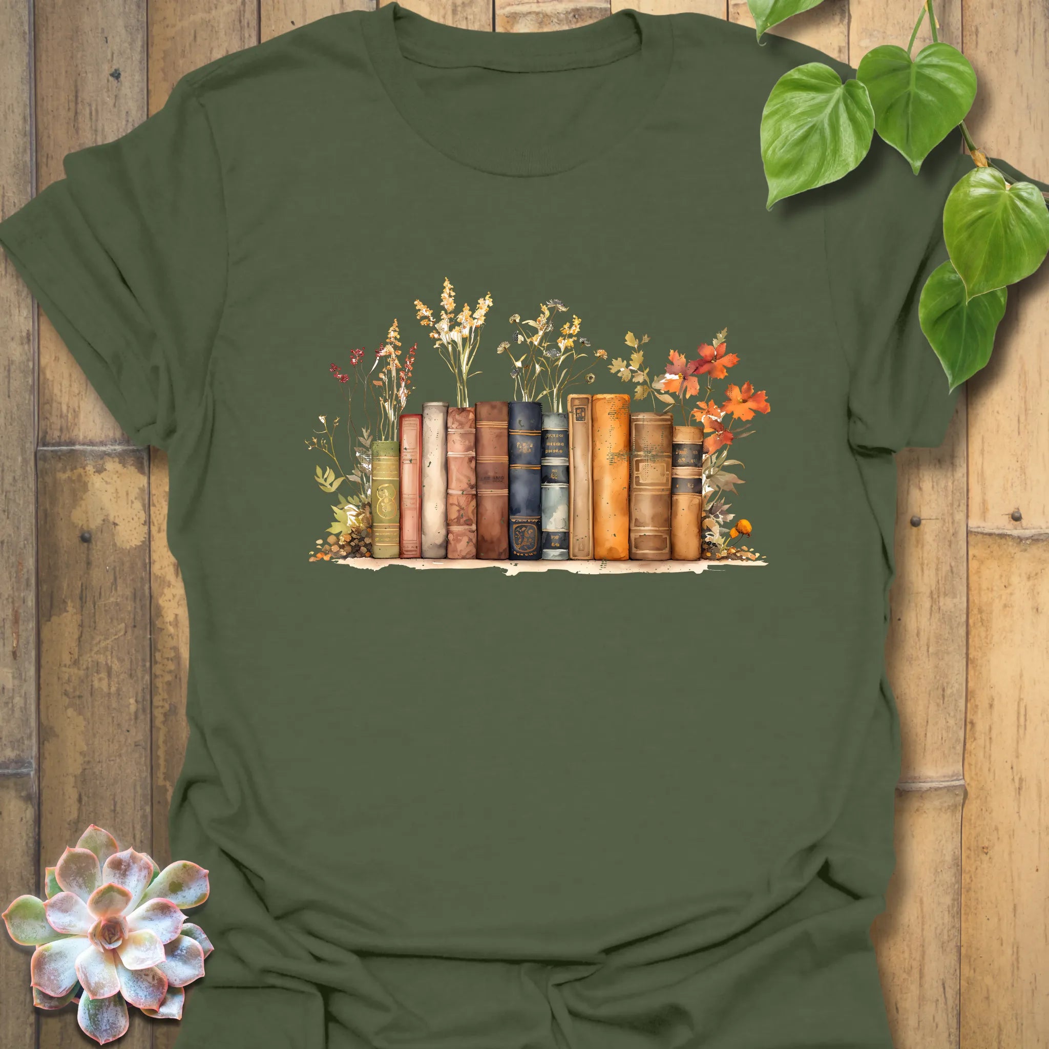 Military green “Wildflower Library” tee with vintage books and floral artwork, earthy tones for garden lovers and readers alike.