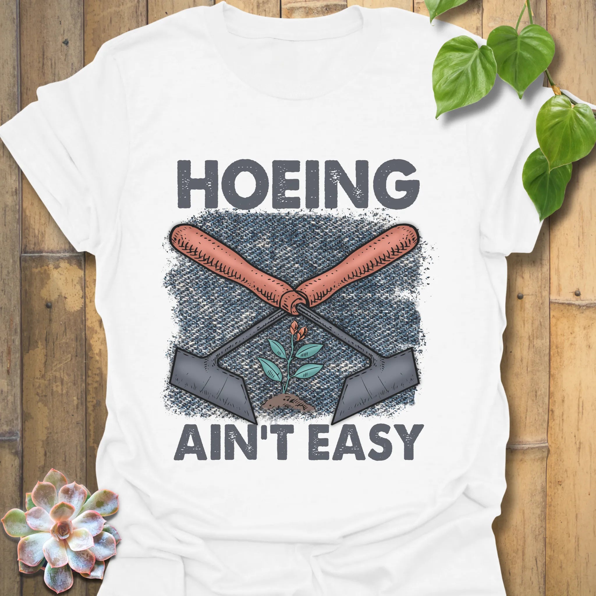 White t-shirt featuring the design Hoeing Ain’t Easy, funny gardening shirt.