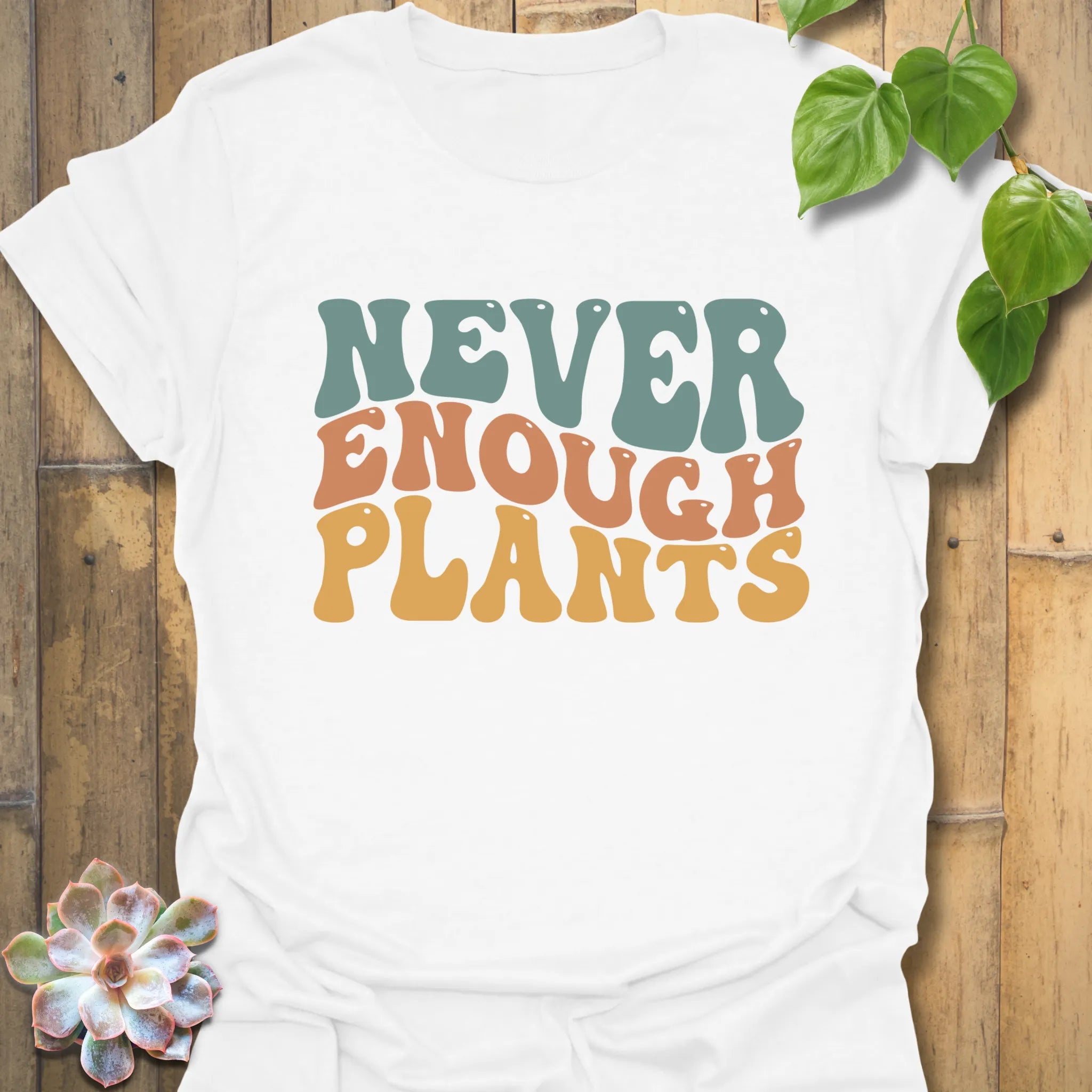 White t-shirt featuring the design Never Enough Plants in bold green text with a leafy graphic.