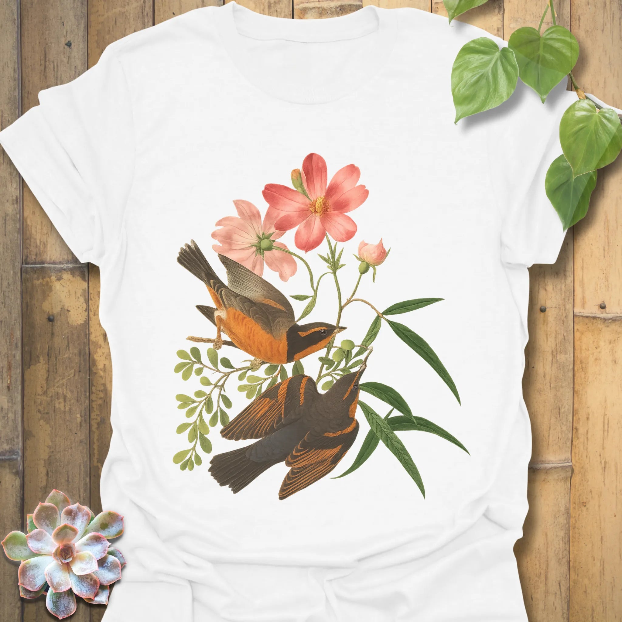 White t-shirt with the Spring Songbirds design showing two detailed birds perched near pink blossoms and leafy branches