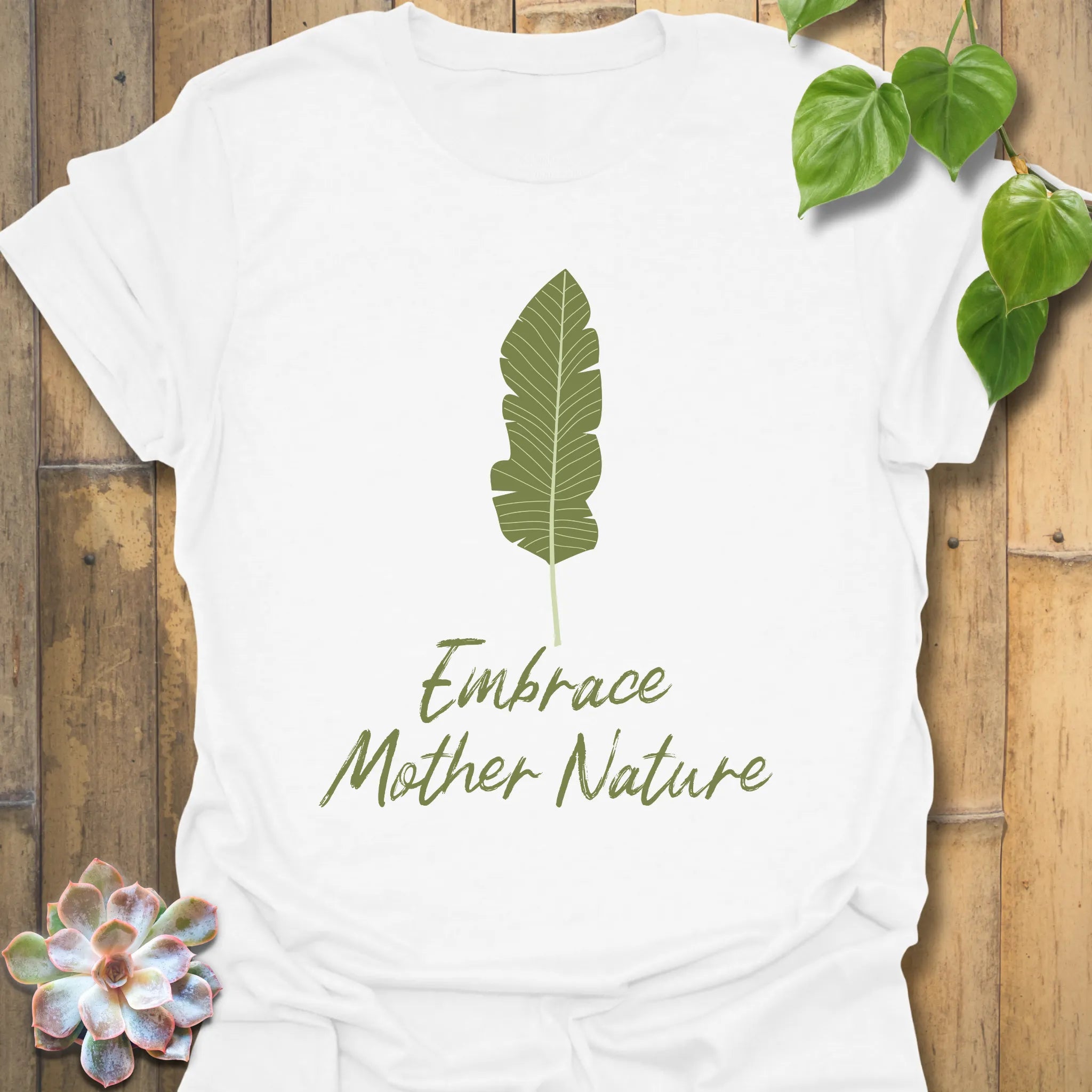 White t-shirt with the words “Embrace Mother Nature” and a minimal leaf print graphic
