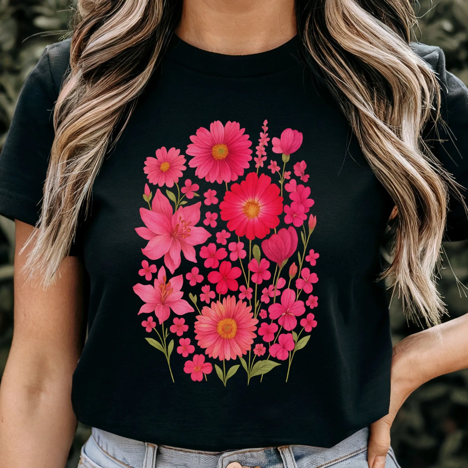 Woman wearing a black “Pink Blossom” T-shirt featuring bright pink flowers — casual floral style on soft Gildan 64000 cotton.