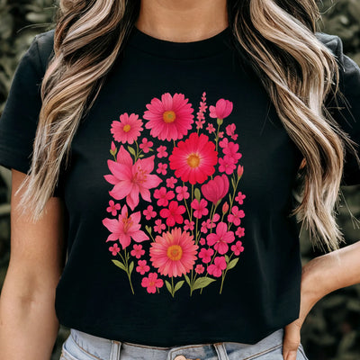 Woman wearing a black “Pink Blossom” T-shirt featuring bright pink flowers — casual floral style on soft Gildan 64000 cotton.