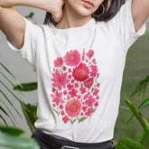 Woman wearing a white “Pink Blossom” T-shirt with vivid pink flower design — cheerful, relaxed fit ideal for everyday wear.