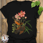 Black t-shirt featuring the Spring Songbirds design with two colourful birds perched among pink flowers and green leaves