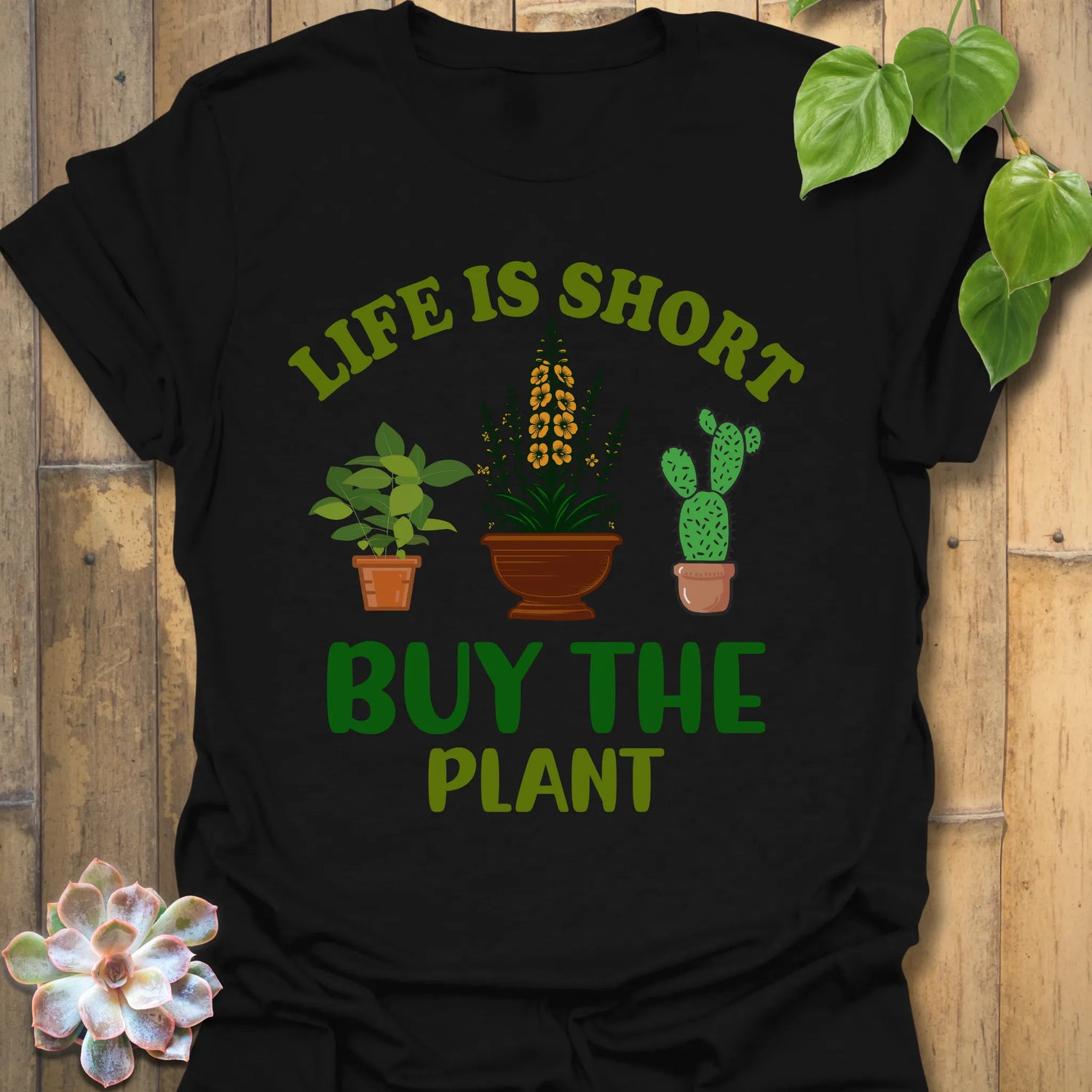 Black t-shirt featuring the design Buy The Plant printed in bold letters, funny gardening shirt.