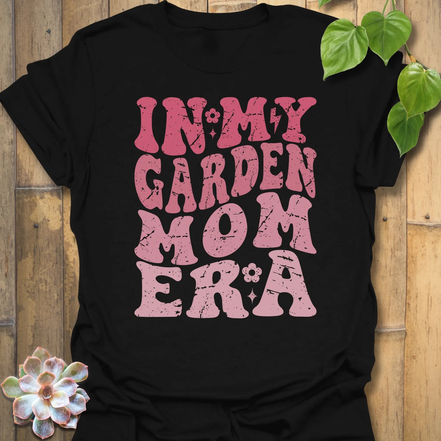 Black t-shirt featuring the design In My Garden Mom Era printed in bold letters, gardening shirt for moms.