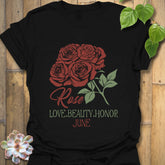 Black t-shirt featuring the design June Rose with a striking rose flower print, a classic floral graphic shirt for versatile wear.