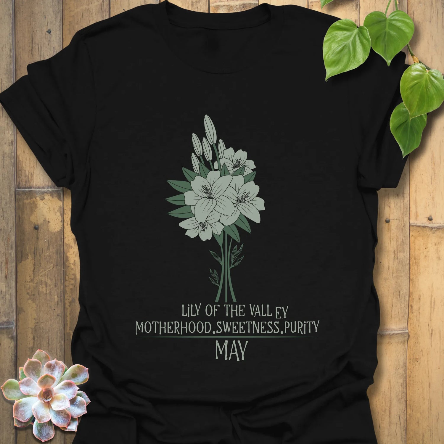 Black t-shirt featuring the design May Lily of the Valley with Rose flower print, a bold botanical shirt for modern floral fashion lovers.