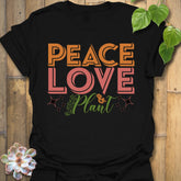 Black t-shirt featuring the design Peace Love Plant printed in bold letters, gardening lover shirt.