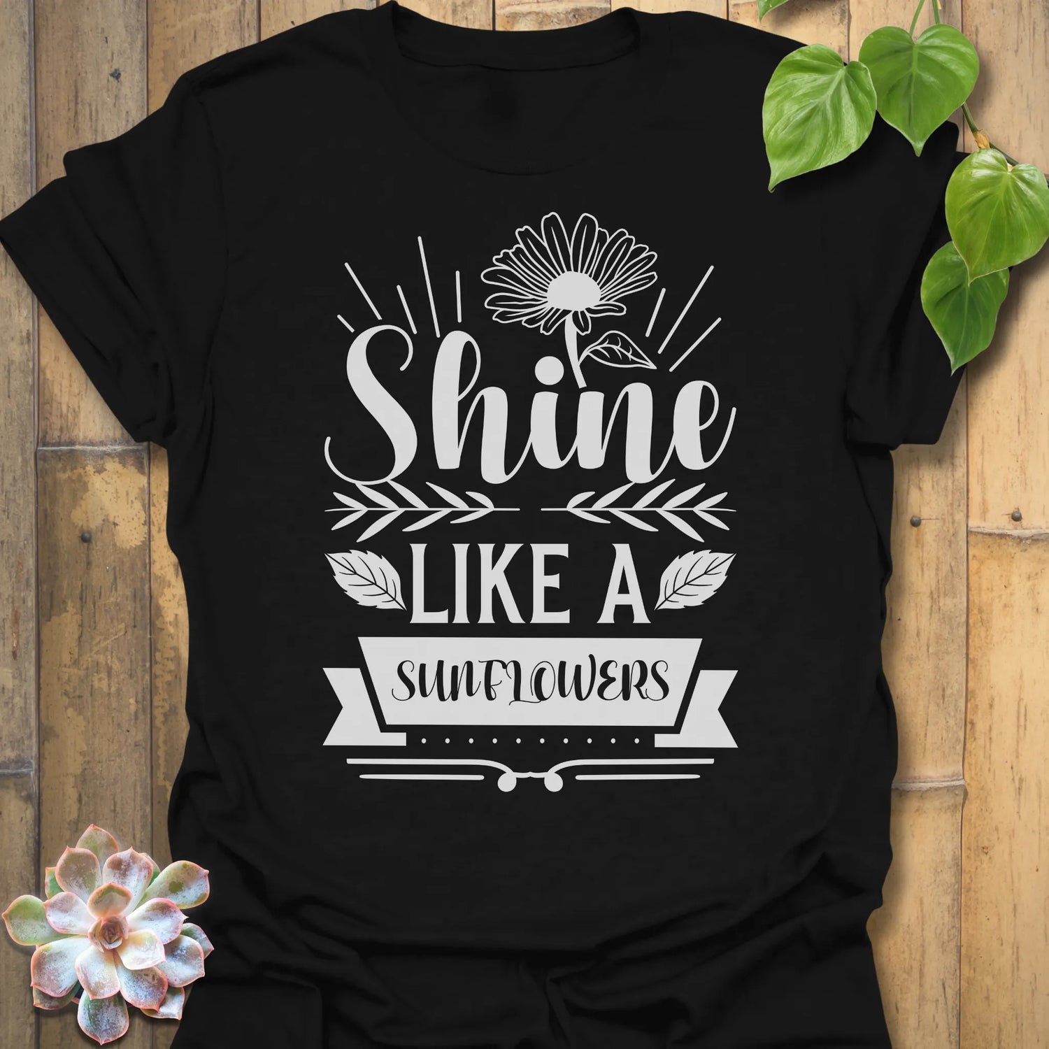 Black t-shirt featuring the design Shine Like A Sunflower printed in bold letters, sunflower lover shirt.