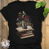 Black t-shirt featuring the design Whiskers & Words printed in books and cats with flowers, cat lover reading shirt.