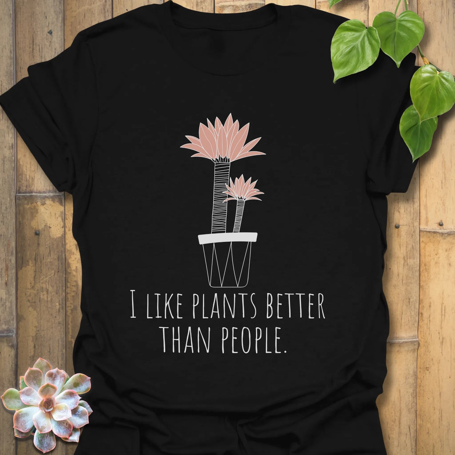 Black t-shirt with the phrase “I like plants better than people” and a flower in a pot printed on the front