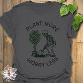 Charcoal t-shirt featuring the design Plant More Worry Less with a skeleton and plants character, modern eco-friendly graphic shirt.