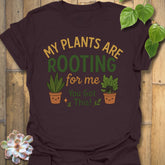 Dark Chocolate t-shirt featuring the design Plants Are Rooting printed in bold letters, gardening graphic tee.
