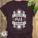 Dark Chocolate t-shirt featuring the design You Are My Sunshine printed in bold letters, nature-inspired graphic tee.