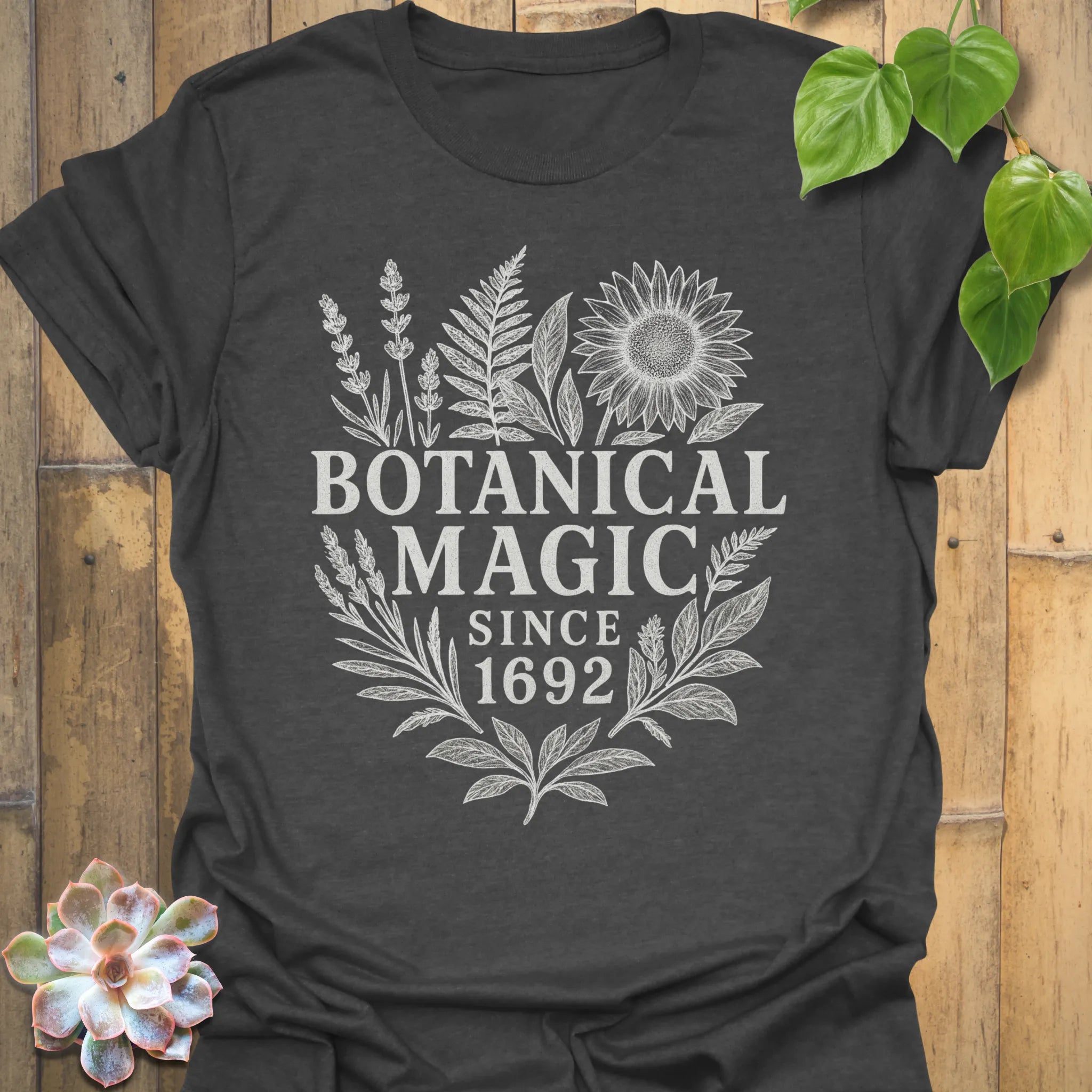 Dark Heather t-shirt featuring the design Botanical Magic printed in bold letters, floral graphic tee.