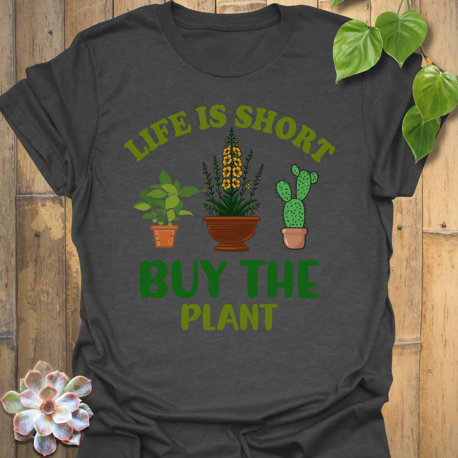 Dark Heather t-shirt featuring the design Buy The Plant printed in bold letters, funny gardening shirt.