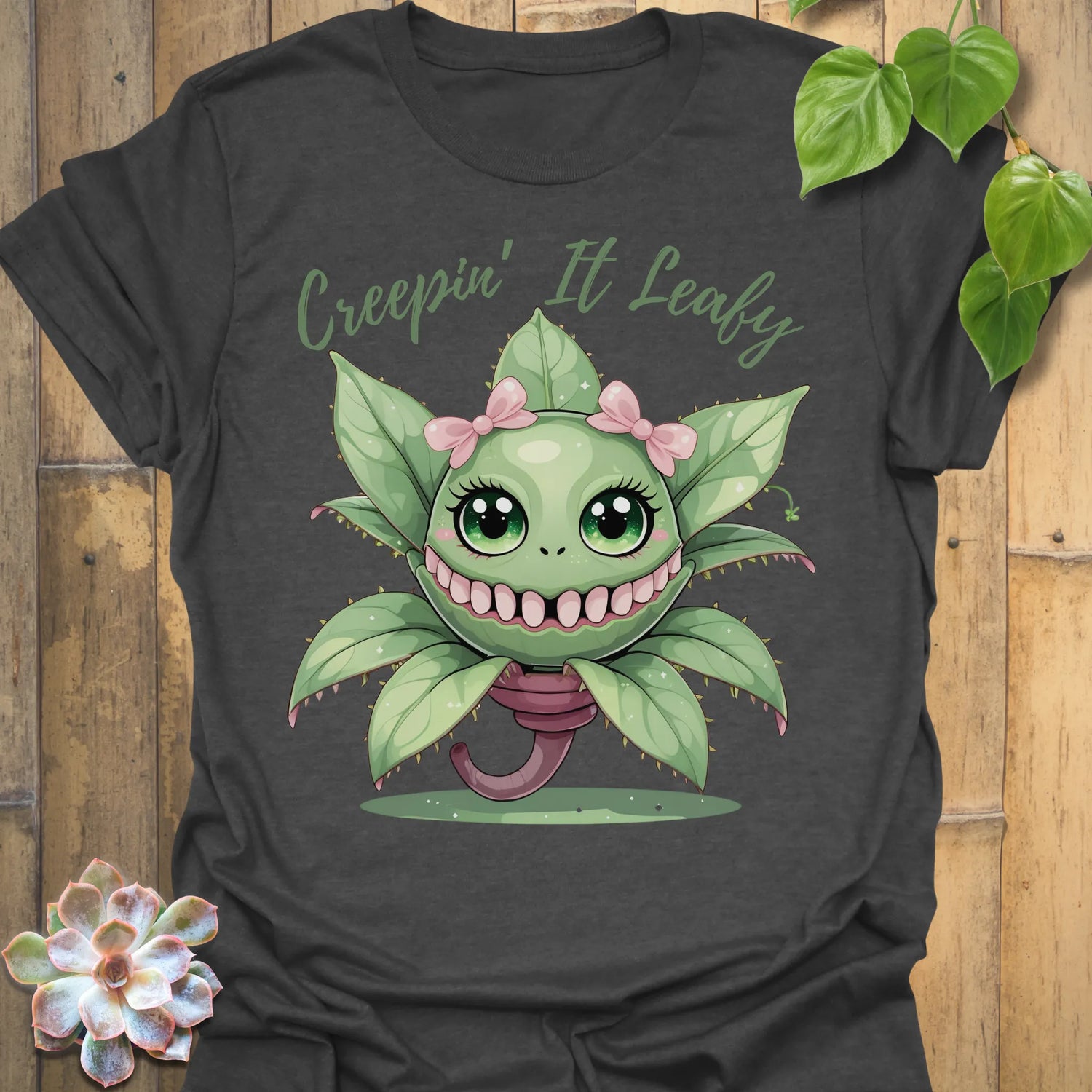 Dark Heather t-shirt featuring the design Creepin’ It Leafy printed in bold black letters, gardening graphic shirt.