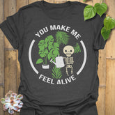 Dark Heather t-shirt featuring the design Feel Alive printed in bold white letters with plants, motivational graphic tee.