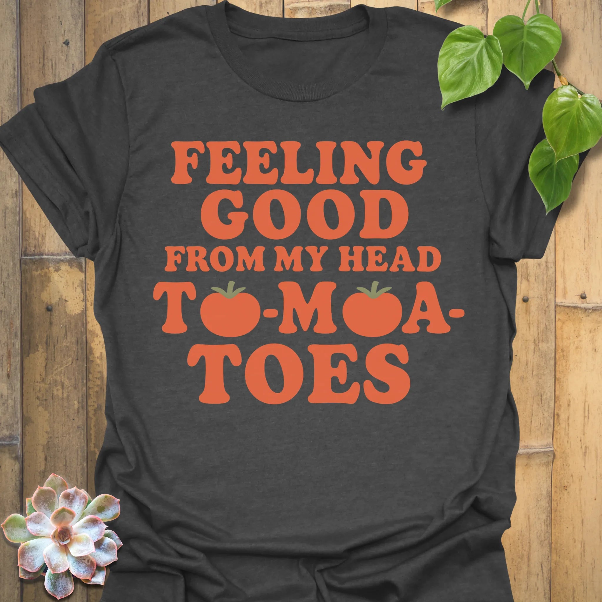 Dark Heather t-shirt featuring the design Feeling Good printed in bold orange letters, feel-good graphic shirt.