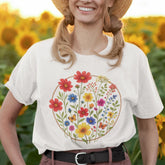 White “Circle of Flowers” T-shirt with a model wearing it. featuring a colourful circular floral design with wildflowers and butterflies, printed on soft Gildan 64000 cotton.