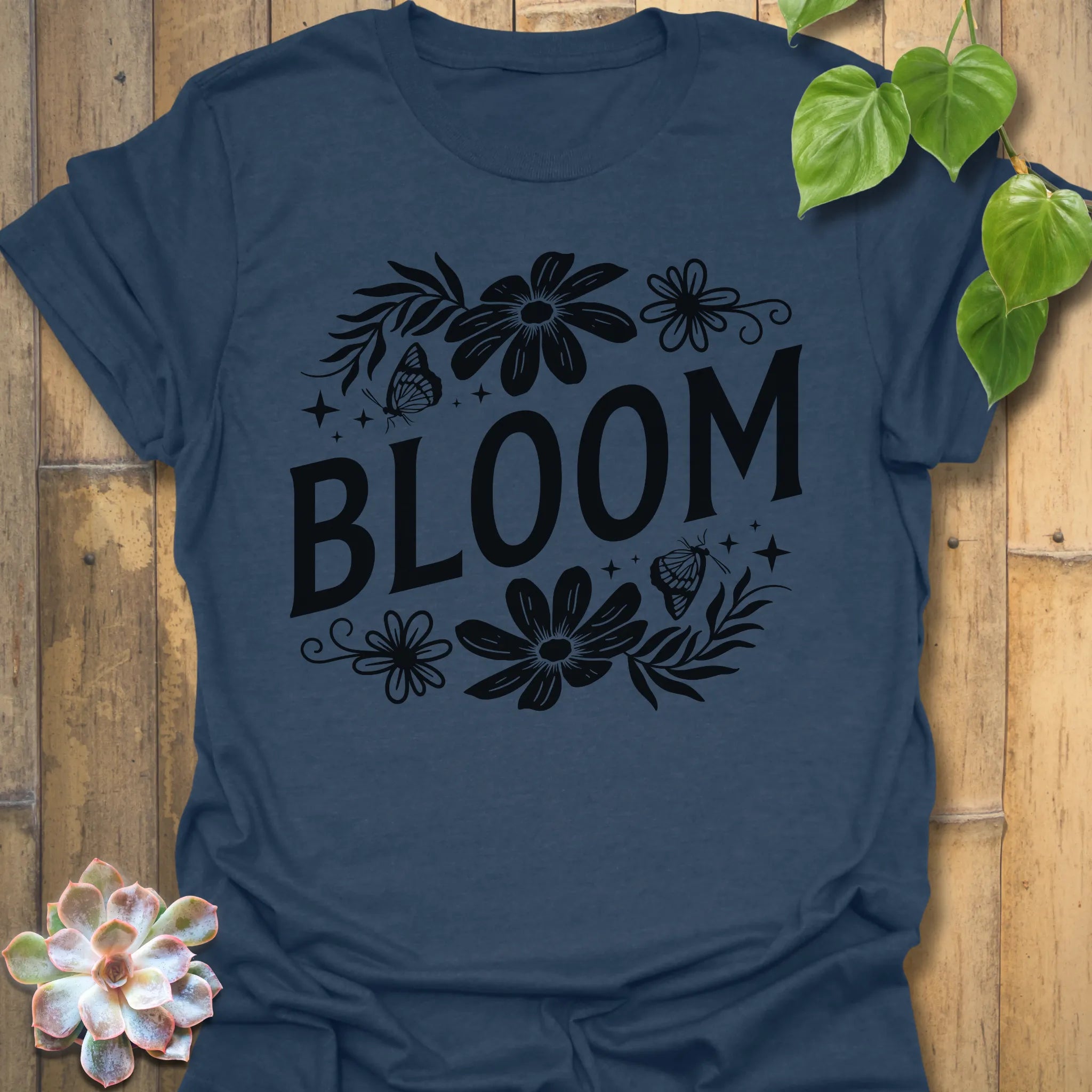 Heather Navy t-shirt featuring the design Bloom printed in bold black letters, floral graphic tee for plant lovers.