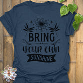 Heather Navy t-shirt featuring the design Bring Your Own Sunshine printed in bold black letters, positive vibes shirt.