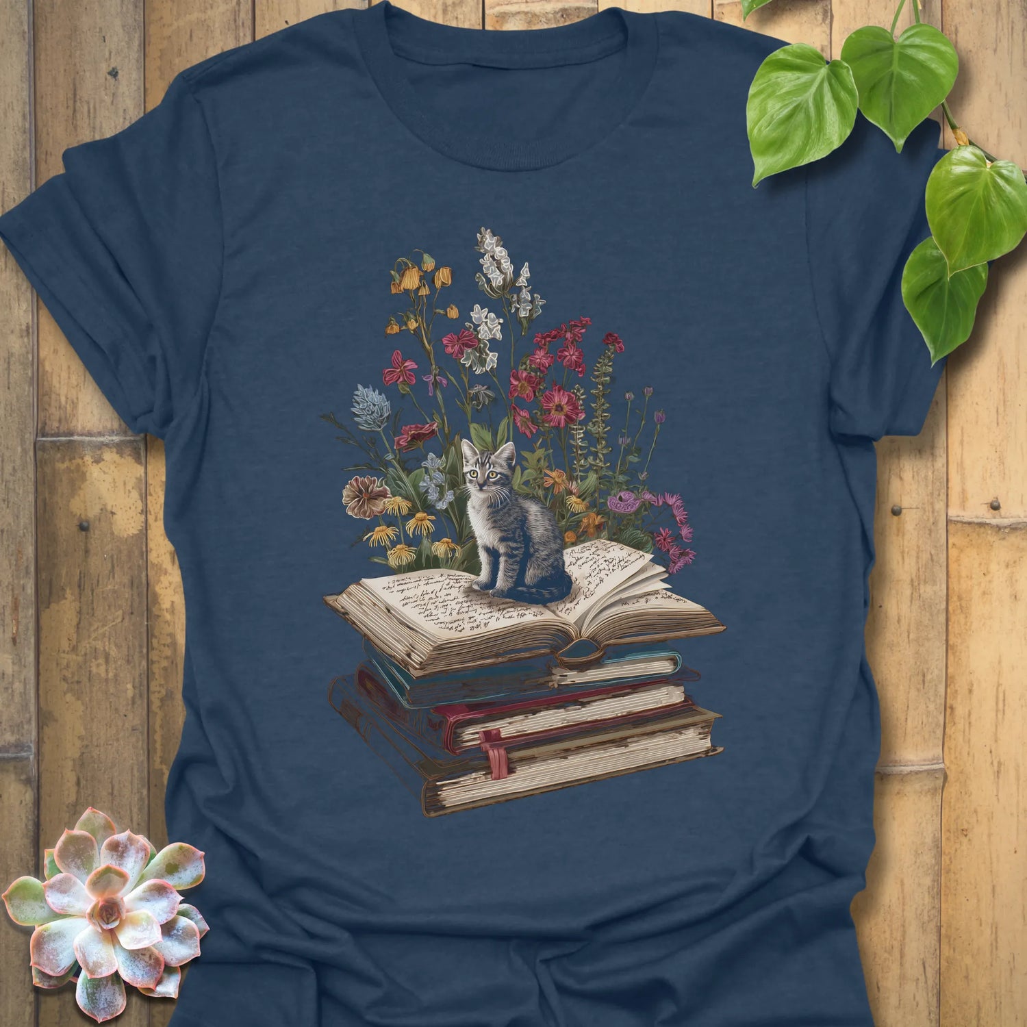Heather Navy t-shirt featuring the design Whiskers &amp; Words printed in books and cats with flowers, cat lover reading shirt.
