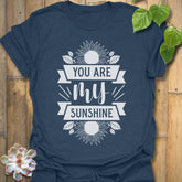 Heather Navy t-shirt featuring the design You Are My Sunshine printed in bold letters, nature-inspired graphic tee.