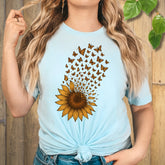A light blue tee featuring a radiant sunflower bursting into butterflies — the perfect mix of strength and serenity for nature lovers.