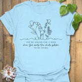 Light Blue t-shirt featuring the design Asking For A Rose printed in black letters and flowers, floral humour shirt.