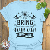 Light Blue t-shirt featuring the design Bring Your Own Sunshine printed in bold black letters, positive vibes shirt.