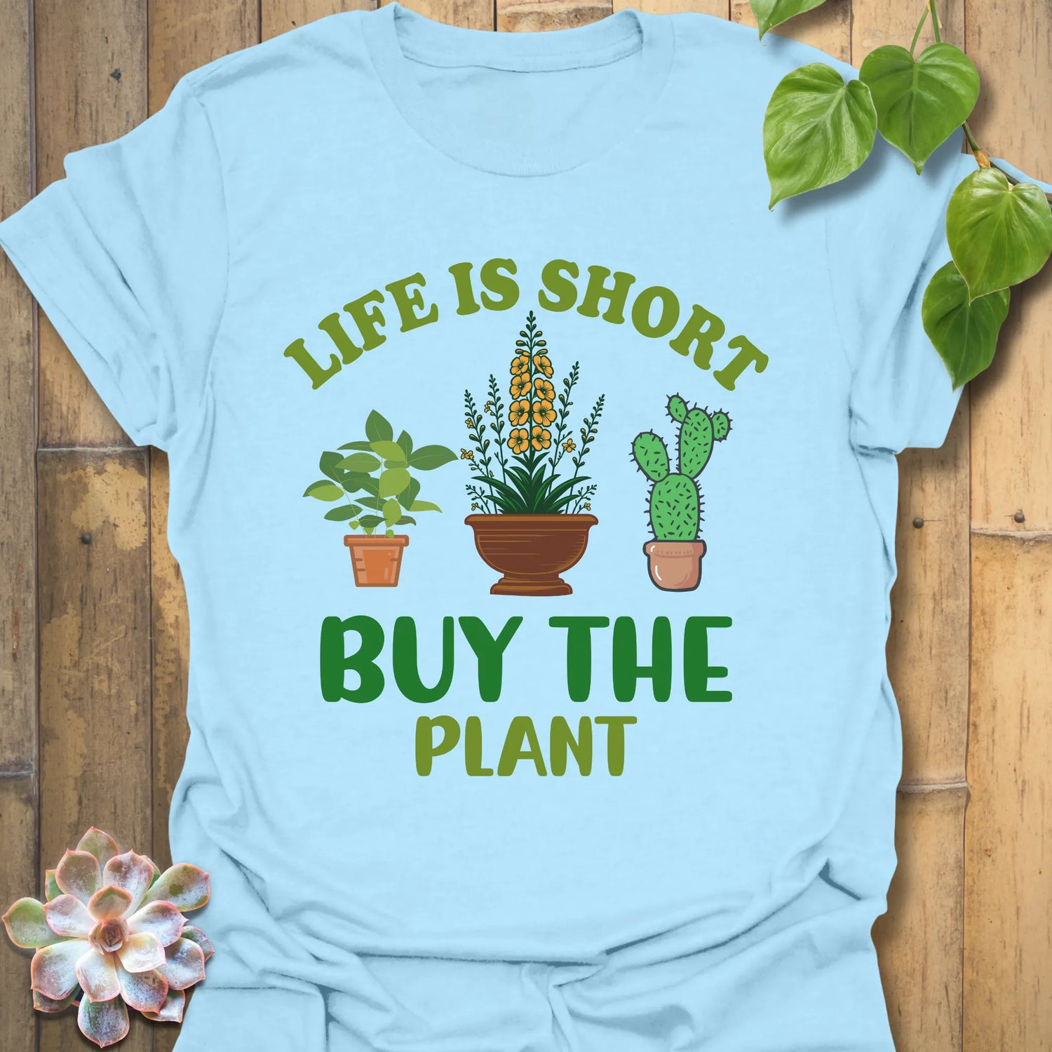 Light Blue t-shirt featuring the design Buy The Plant printed in bold letters, funny gardening shirt.