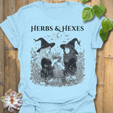 Light Blue t-shirt featuring the design Herbs & Hexes printed in bold black letters, botanical witch t-shirt.