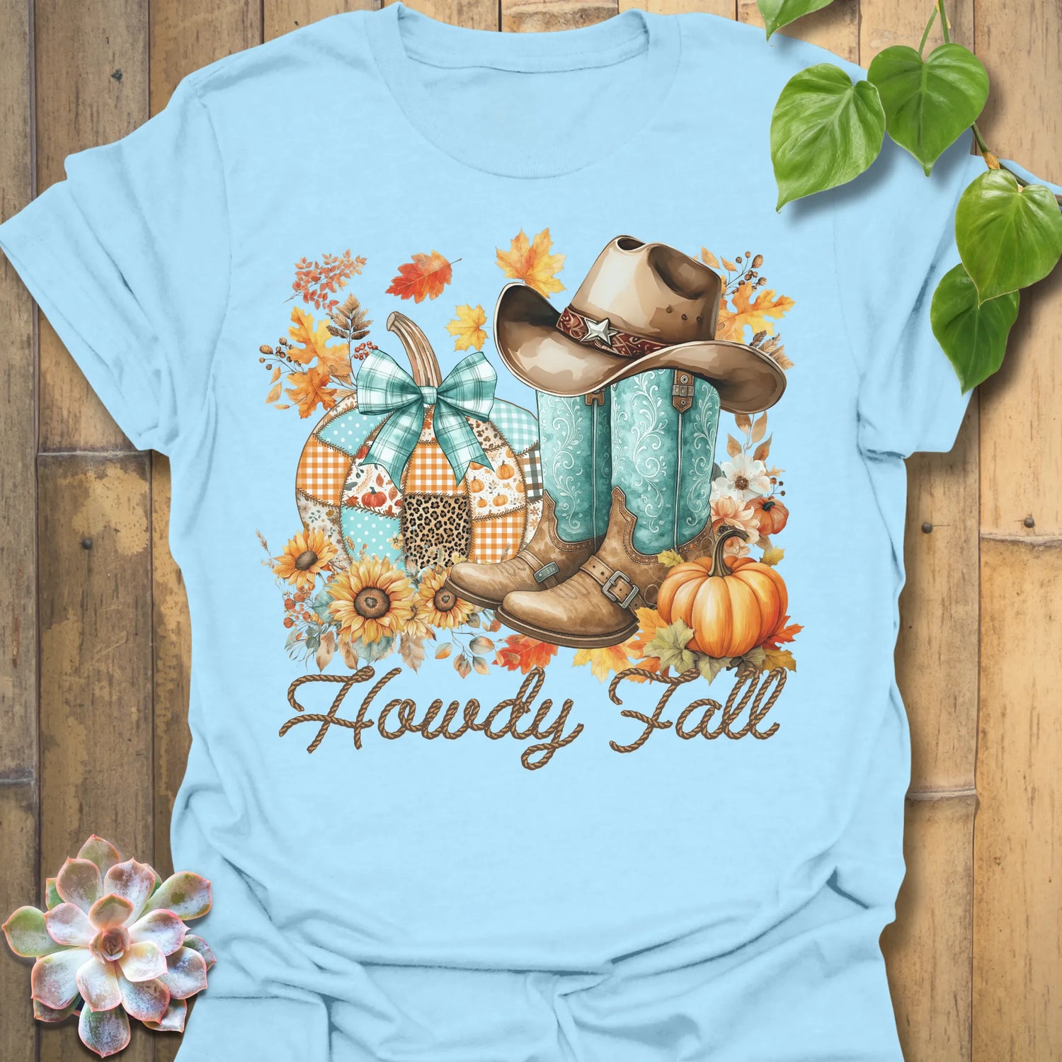 Light Blue t-shirt featuring the design Howdy Fall printed in brown letters, cute fall aesthetic shirt.