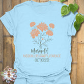 Light Blue t-shirt featuring the design October Marigold printed with a bright marigold flower, a stylish nature-inspired floral tee.