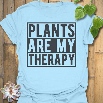 Light Blue t-shirt featuring the design Plants Are My Therapy printed in bold letters, plant lover shirt.