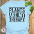 Light Blue t-shirt featuring the design Plants Are My Therapy printed in bold letters, plant lover shirt.